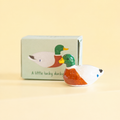 Small ceramic mallard lucky duck token displayed in front of its illustrated gift box.