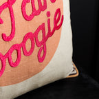 Close up of bright pink embroidered lettering on the peach and cream Yes Sir, I Can Boogie cushion.