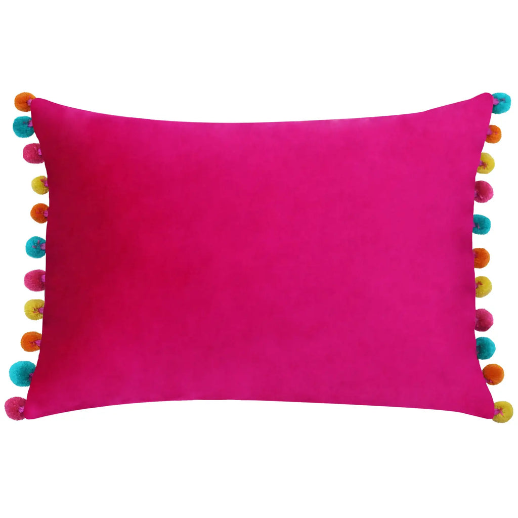 Bright pink velvet rectangular cushion with colourful turquoise, orange, yellow and pink pom pom edging.