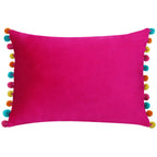 Bright pink velvet rectangular cushion with colourful turquoise, orange, yellow and pink pom pom edging.