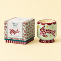 Ocean Tide soy wax candle in a hand painted mint green ceramic vessel with pink koi fish and stars, beside its matching box.