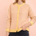 Woman wearing a soft pink and yellow striped knitted cardigan with a relaxed fit and button front.