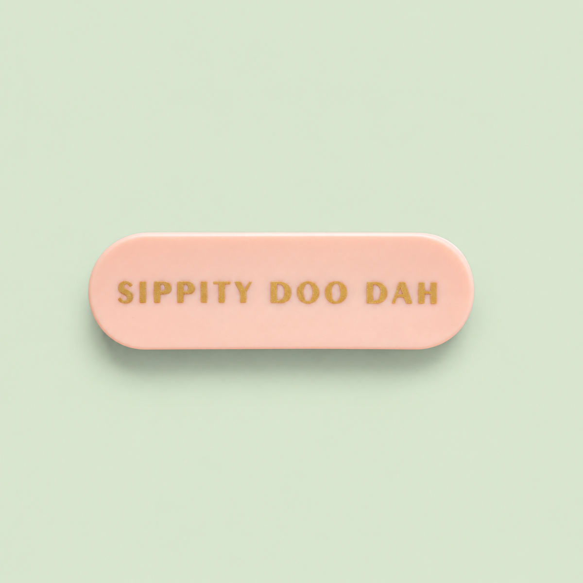 Pink Sippity Doo Dah reusable straw carry case with gold lettering on a pale green background.
