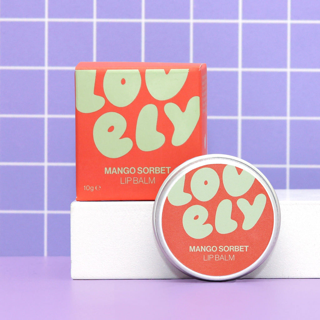 Mango Sorbet Lip Balm 10g tin and colourful orange box on a lilac background.