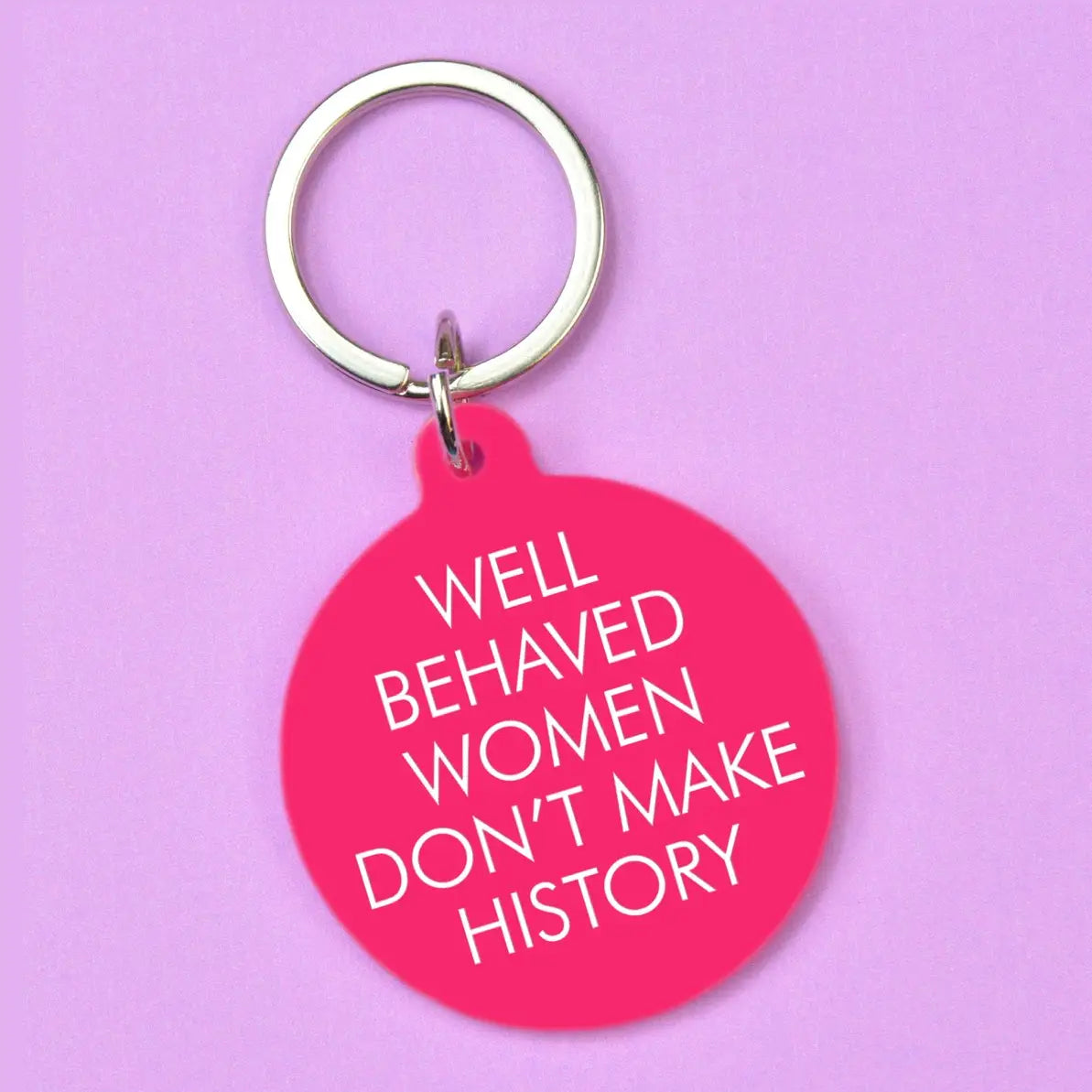 Hot pink round statement keyring with white Well Behaved Women Don't Make History lettering and silver-tone keyring.