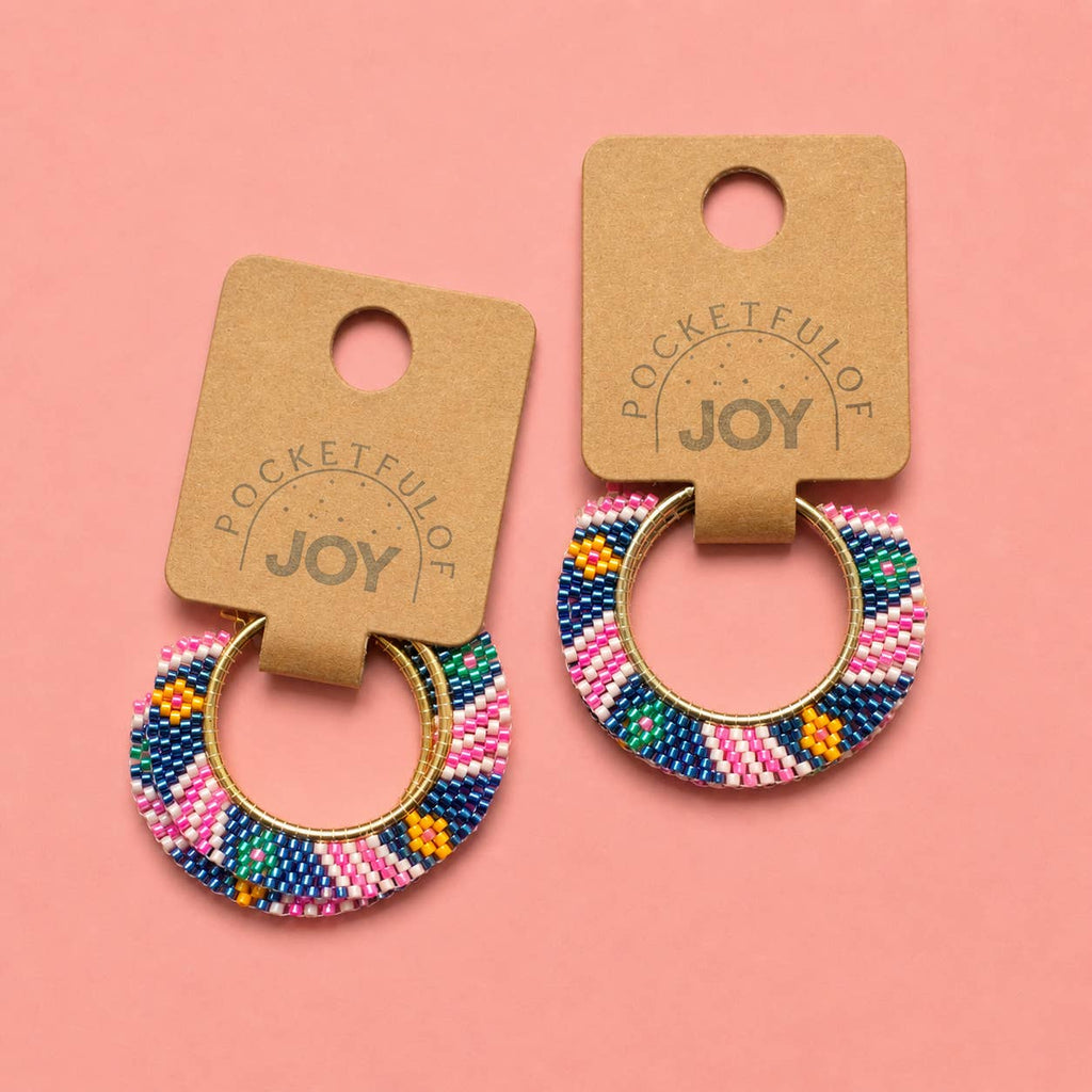 Pair of pink multi geometric beaded hoop earrings displayed on Pocketful of JOY jewellery cards.
