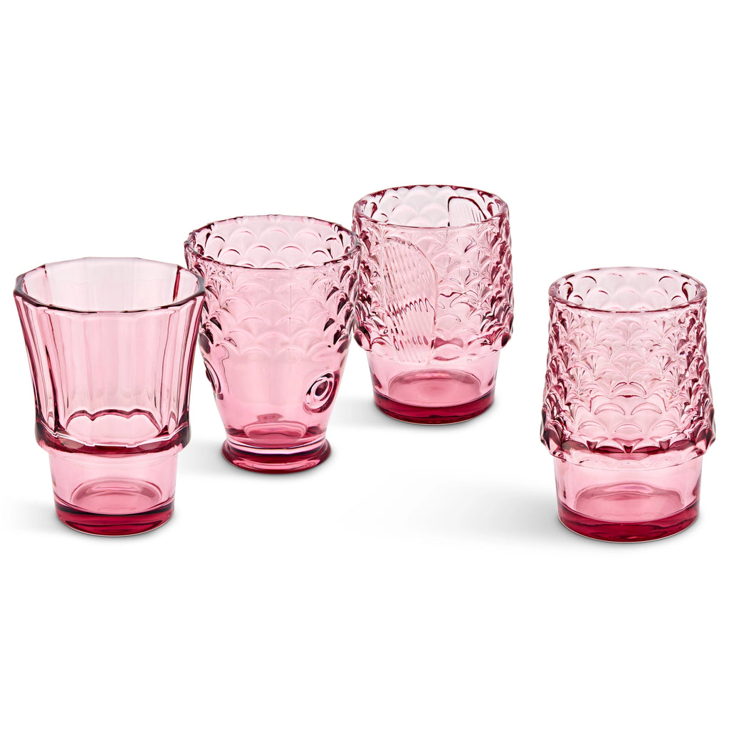 Pink fish glasses partly stacked with two tumblers filled with drinks and ice.