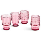 Pink fish glasses partly stacked with two tumblers filled with drinks and ice.
