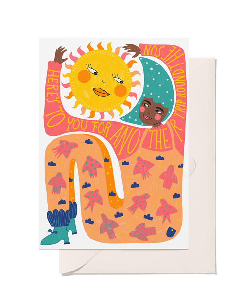 Illustrated birthday card with smiling sun and moon, colourful winding path and Here’s To You For Another Trip Round The Sun message.