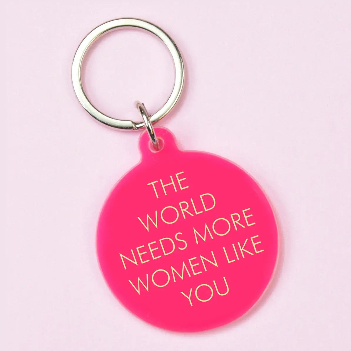 Hot pink round statement keyring with gold The World Needs More Women Like You lettering and silver-tone keyring.
