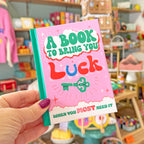 hand holding a little book to bring you luck