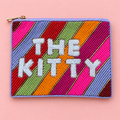 Colourful hand beaded The Kitty pouch with rainbow stripes, white lettering and gold zip on a pale pink background.