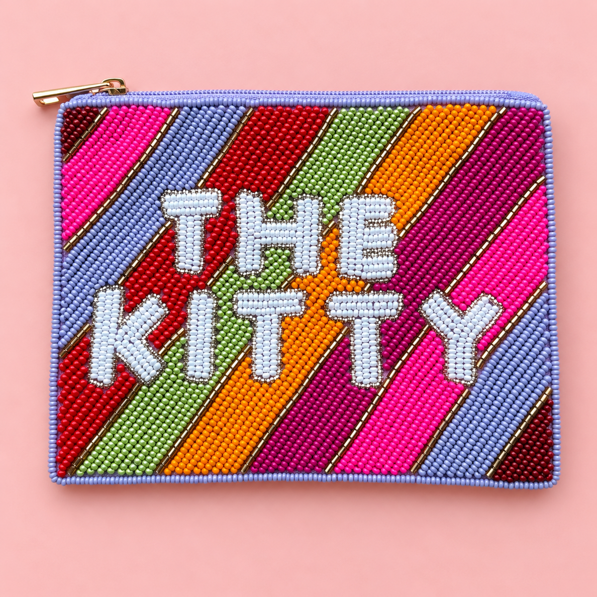 Colourful hand beaded The Kitty pouch with rainbow stripes, white lettering and gold zip on a pale pink background.