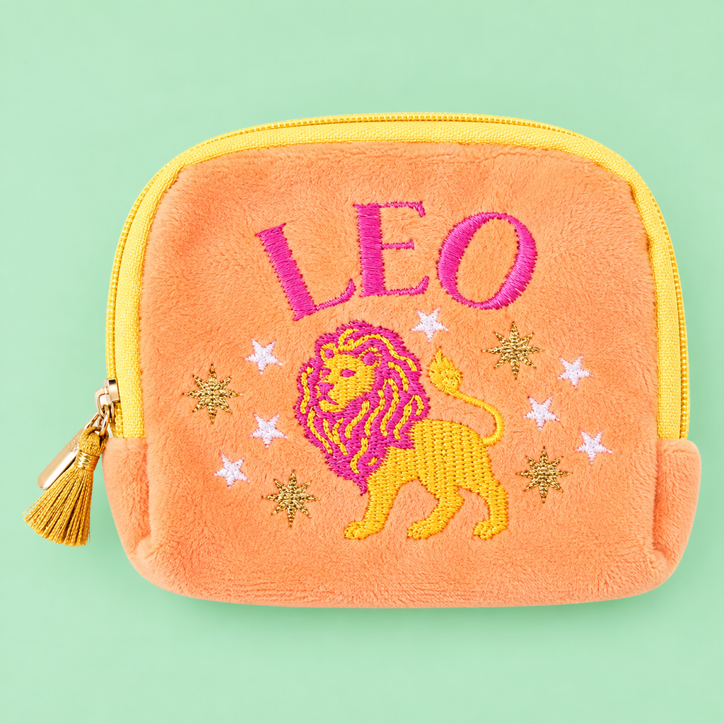 Peach orange Leo velvet pouch with bright pink and yellow lion embroidery on a soft green background.