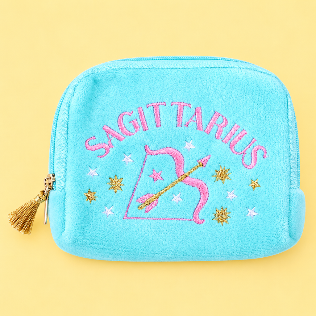 Turquoise velvet Sagittarius pouch with colourful embroidered stars, bow and arrow design and gold tassel zip on yellow background.