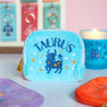 Turquoise velvet Taurus zodiac pouch with deep blue embroidered bull, gold stars and gold tassel zip.