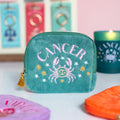 Teal velvet Cancer zodiac pouch with pink embroidered crab, gold and white stars and gold tassel zip.