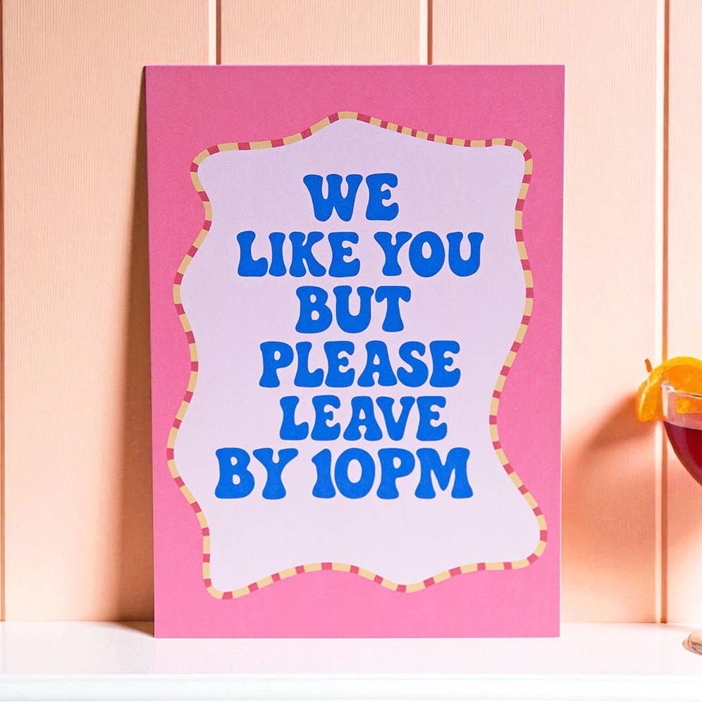 Colourful We Like You But Please Leave By 10PM A5 print with bold blue lettering and a bright pink border.