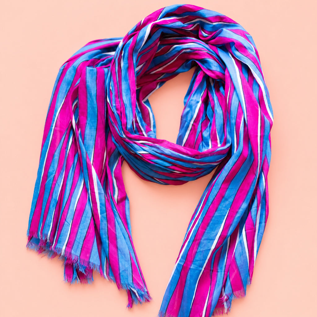 Joyful pink, blue and white striped cotton scarf loosely styled to show its vibrant colours and soft frayed edges.