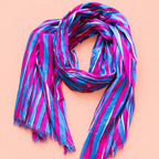 Joyful pink, blue and white striped cotton scarf loosely styled to show its vibrant colours and soft frayed edges.