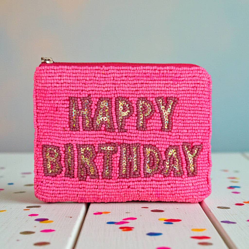 Bright pink beaded zip pouch featuring shimmering ‘Happy Birthday’ lettering, displayed upright against a pale background.