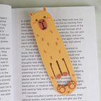 Cute orange capybara reading light and bookmark resting inside an open book.