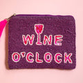 Purple beaded pouch with pink and white ‘WINE O’CLOCK’ lettering, wine glass motif and bright pink tassel.