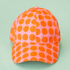 Cheerful pink baseball cap covered in bold orange polka dots for an instant burst of colour.