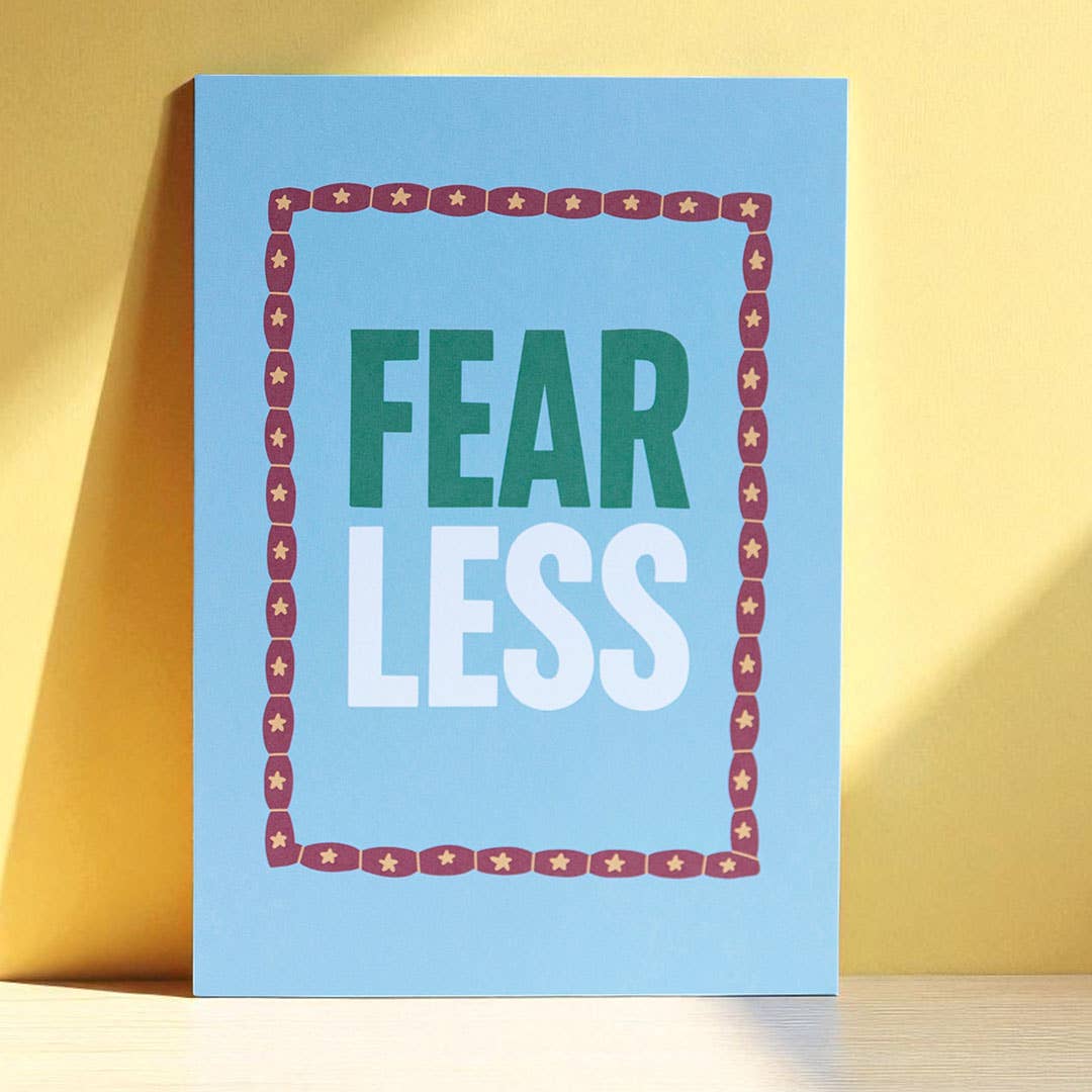 Cheerful blue Fear Less A5 print with bold green and white lettering and a playful star patterned border.

