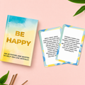 Be Happy box with colourful activity and quote cards displayed on a pale pink background.