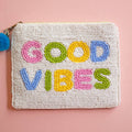 Beaded zip pouch with colourful ‘Good Vibes’ lettering in pink, green, yellow and blue, with a blue pom pom zip pull.