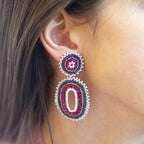 Pink and blue beaded oval statement earring worn on the ear, showing the colourful layered design.