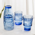 Blue fish shaped stacking glasses separated and filled with drinks on a table.