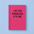 Bright pink A7 fabric hardback notebook with black I’m The Problem It’s Me text on a pale blue background.