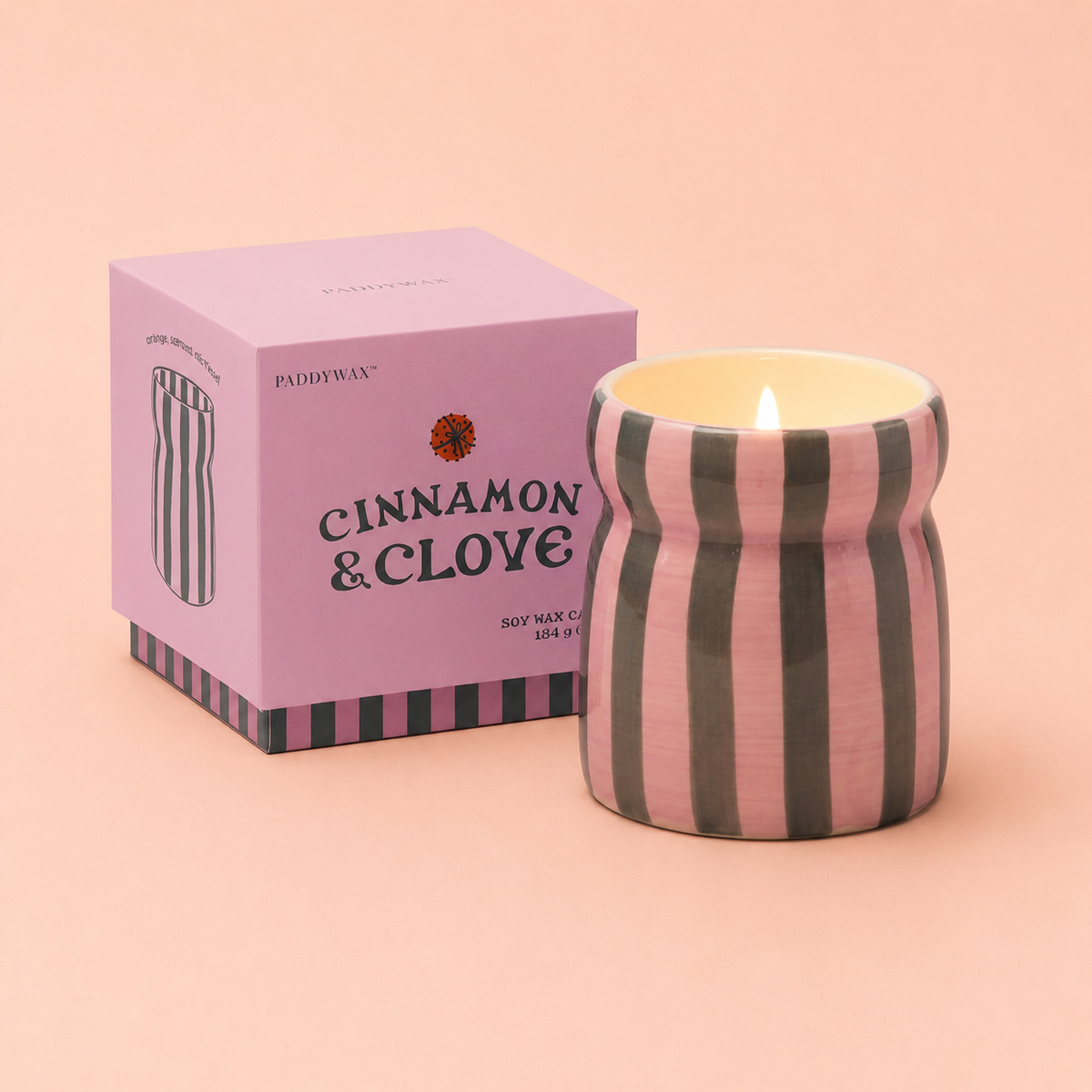 Cinnamon and Clove soy wax candle in a pink and deep green striped ceramic vessel beside its pink presentation box.