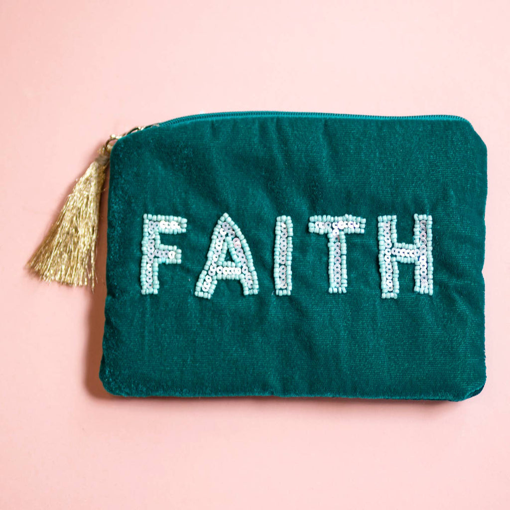 Teal velvet zip pouch with pale beaded ‘FAITH’ lettering and gold tassel detail.