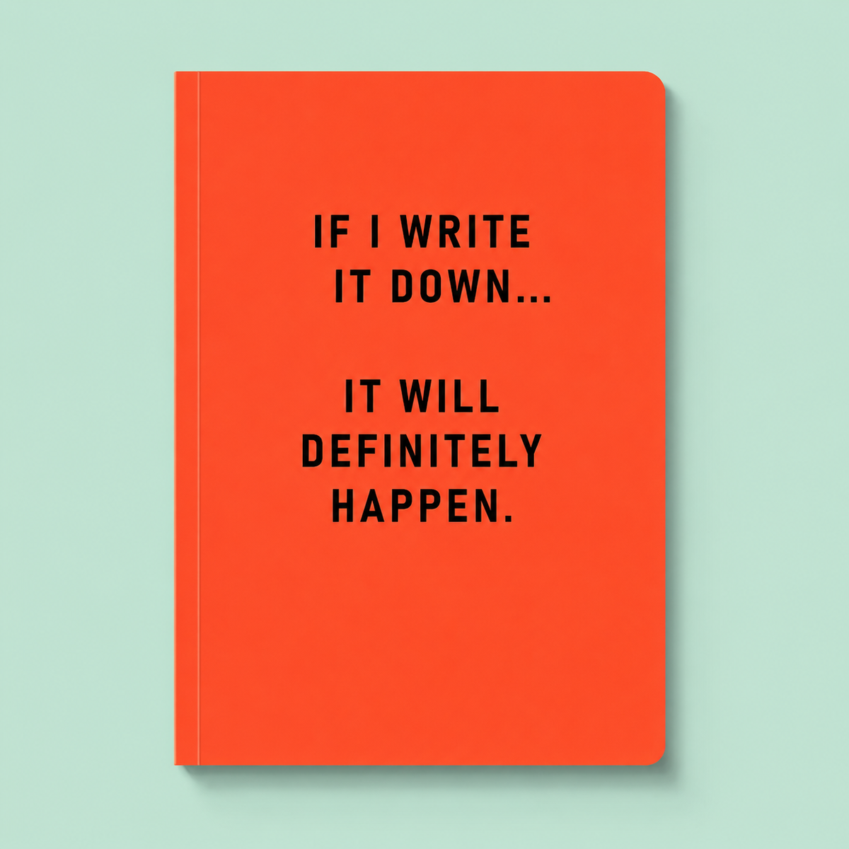 Bright orange A5 notebook with black text reading If I write it down it will definitely happen.