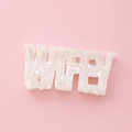Pearlescent white WIFEY claw hair clip decorated with small pearl details on a soft pink background.