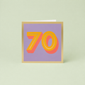 Colourful 70th birthday card with large orange number 70, coral shadow detail, soft lilac background and metallic gold foil border.