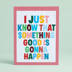 Colourful A5 art print reading “I Just Know That Something Good Is Gonna Happen” in bright lettering with a soft pink border.