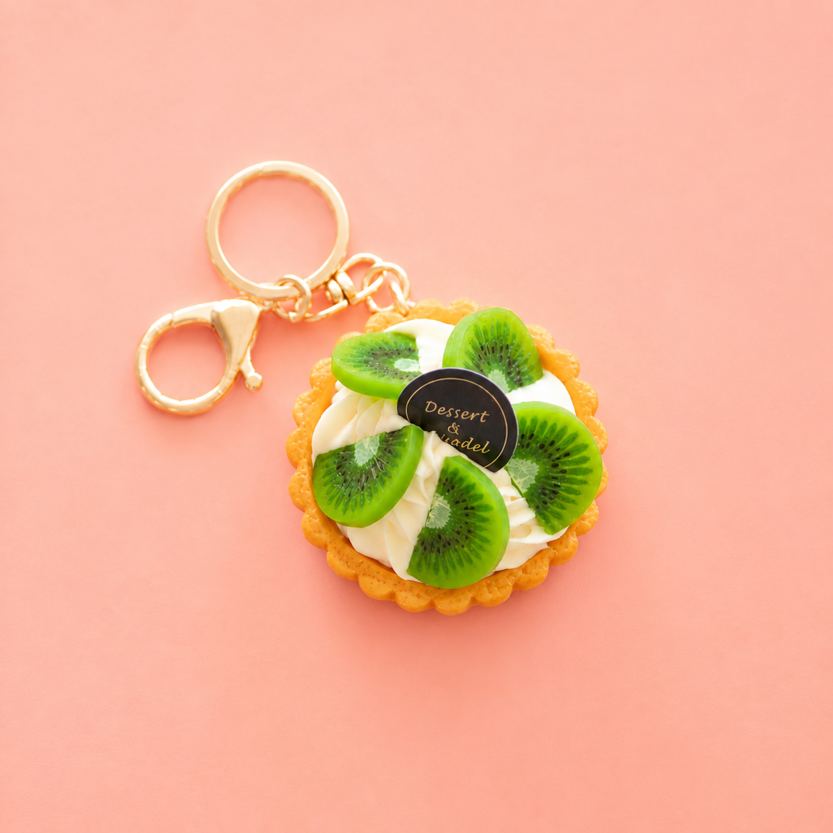 Realistic kiwi fruit tart bag charm keyring with green kiwi slices, cream detailing, golden pastry base and gold tone clips.