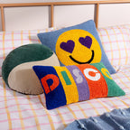 Colorful textured pillows on a bed with plaid bedding