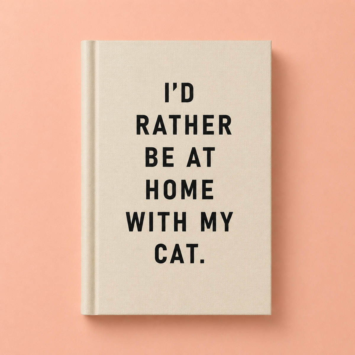 Cream A7 fabric hardback notebook with black I’d Rather Be At Home With My Cat text on a peach background.