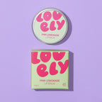Pink Lemonade Lip Balm 10g tin and colourful box photographed on a lilac background.