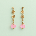 Pair of limited edition gold plated drop earrings with textured discs and frosted neon pink faceted glass beads on pale mint background.