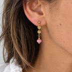 Close up of woman wearing limited edition gold plated drop earrings with frosted neon pink faceted glass beads.
