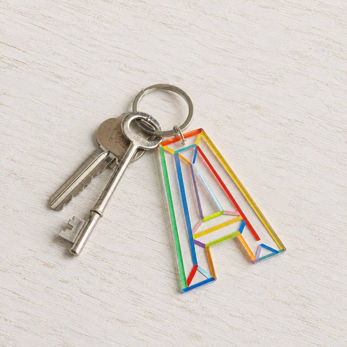 Colourful acrylic letter A keychain with multicoloured detailing attached to a set of keys.