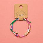 Pink, turquoise and gold adjustable beaded bracelet displayed on a Pocketful of JOY jewellery card.