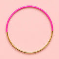 Vibrant pink dip enamel stacking bangle with polished gold tone detailing on a pale pink background.