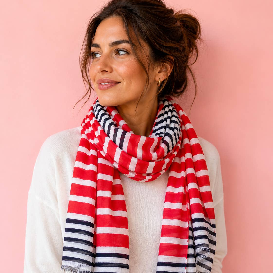Cheerful red, white and navy striped cotton scarf wrapped generously over a soft white jumper for a bright, polished look.